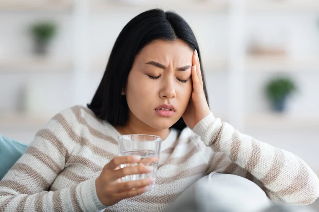Frau hält den Kopf – Alltagslast, Symbolbild: Was kann ich gegen einen Reizdarm tun?
